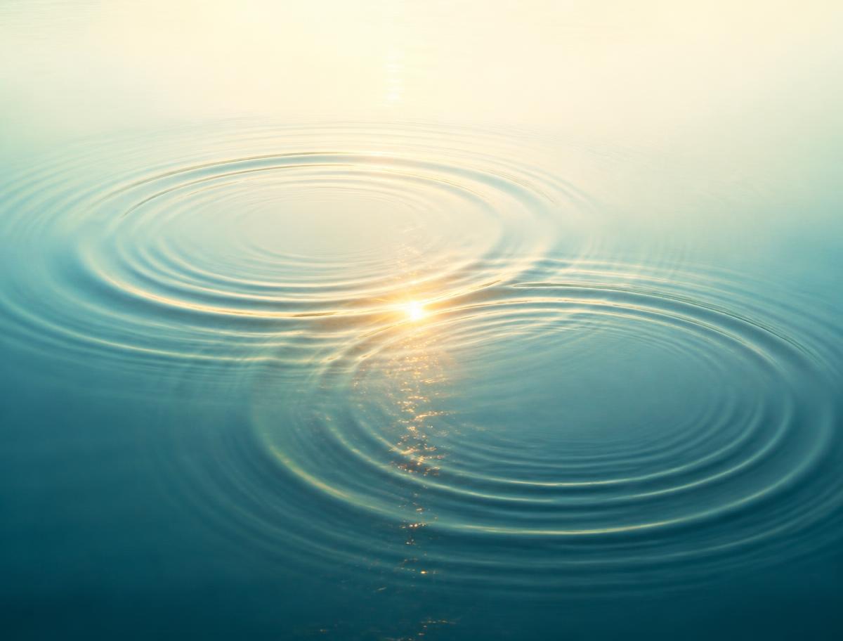 Zwei sich überschneidende Wasserkreise mit goldenem Lichtpunkt im Schnittpunkt